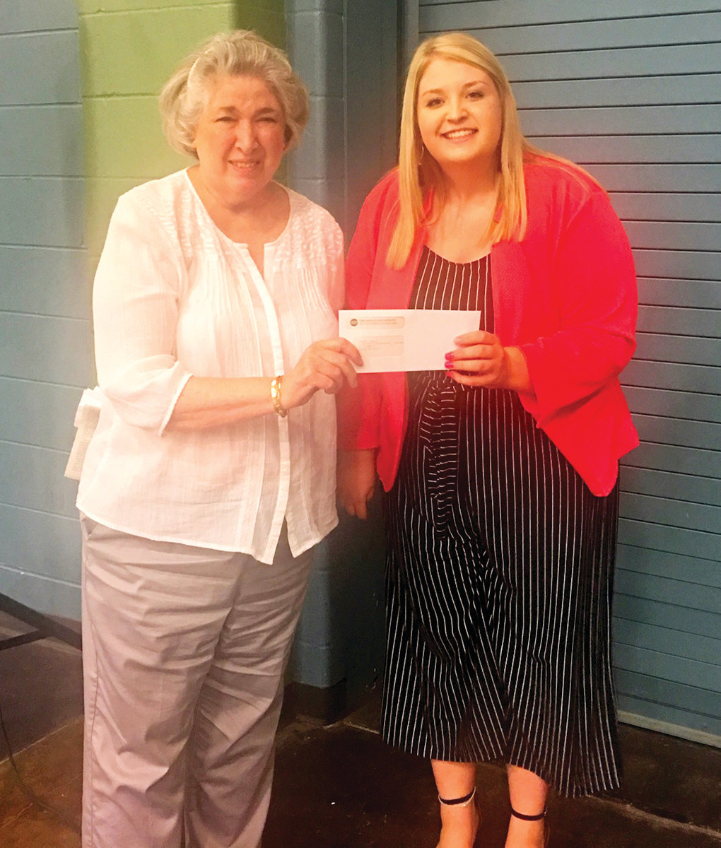 Paula Hilkemeyer presents the first installment of the Gilbert G. Hilkemeyer Scholarship to Reagan Limbach of Eugene Friday’s annual meeting of Three Rivers Electric Cooperative members.