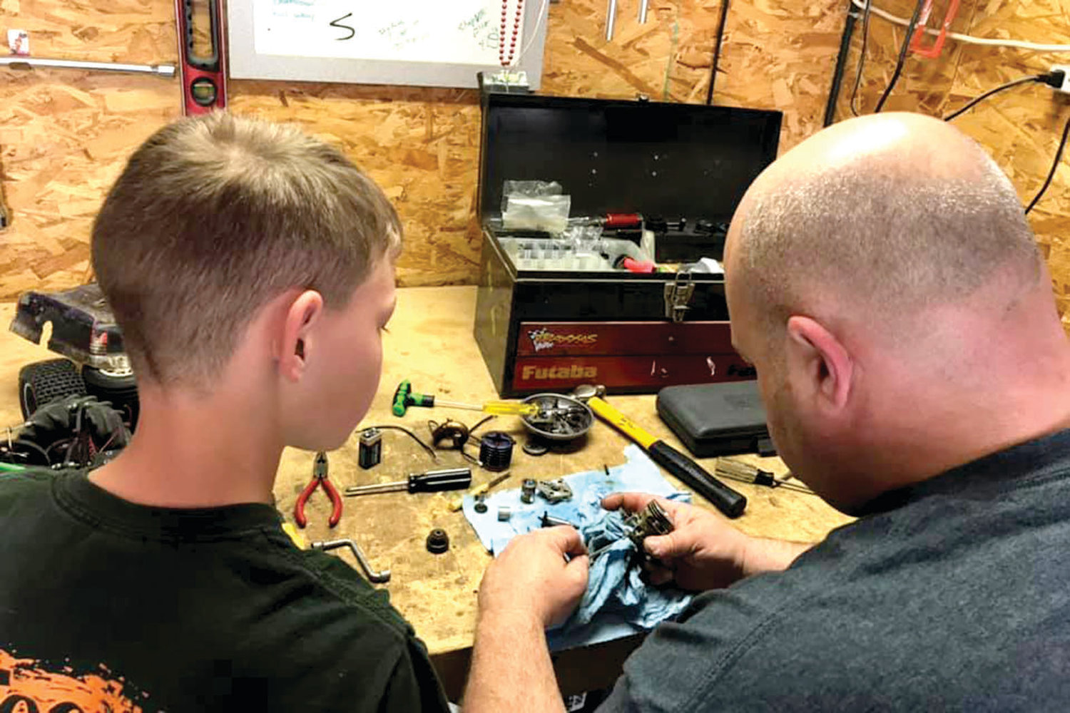 Craig Leivian teaches his son, Colton, some automotive skills while rebuilding an RC car nitro motor.