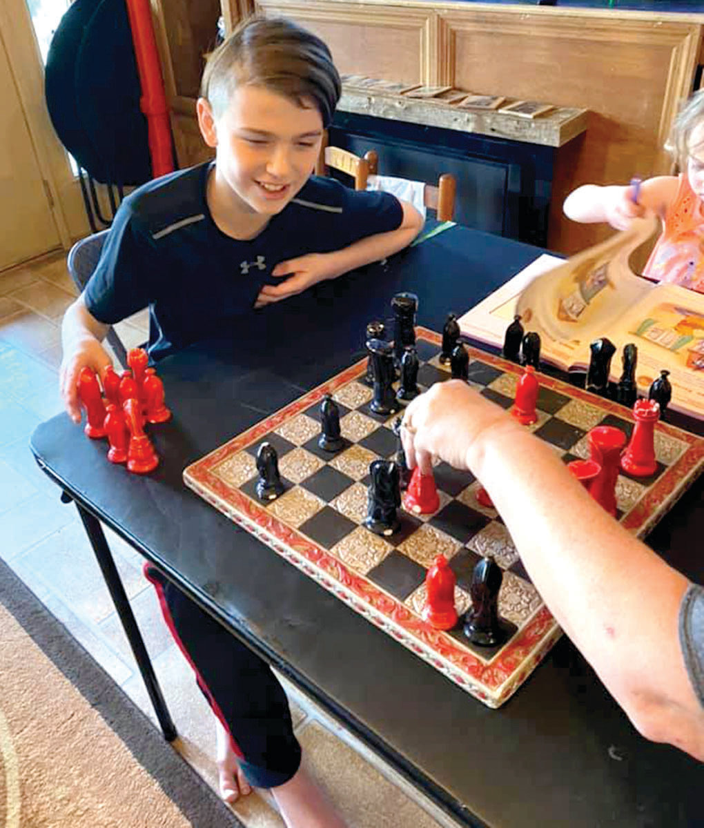 Tommy Scheulen plays chess with his mother, Cassie Sneller.