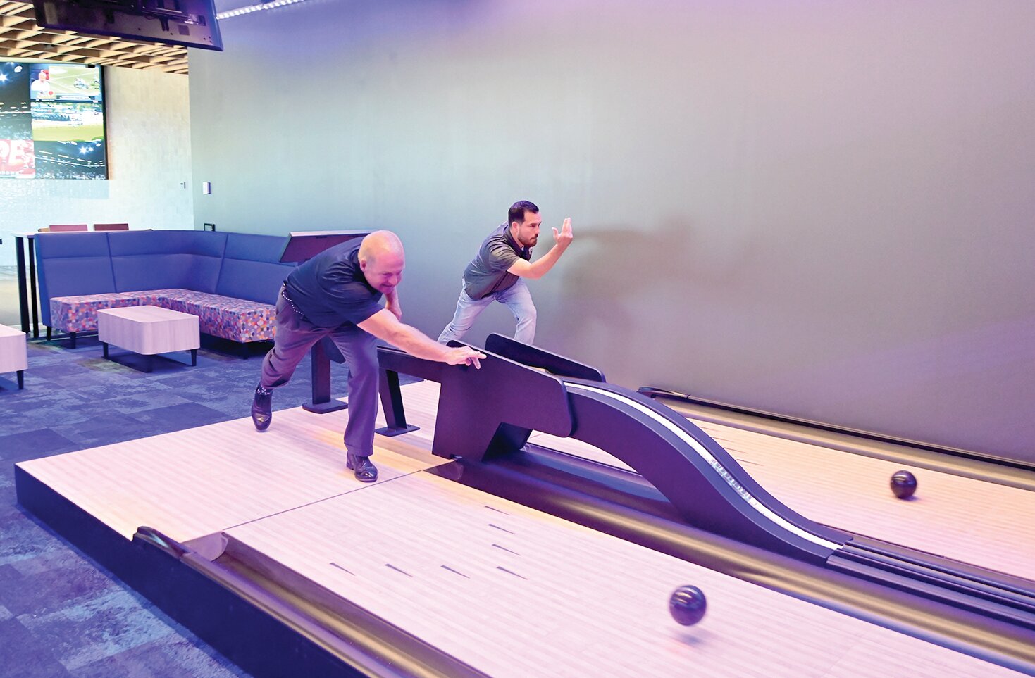 State Tech President Dr. Shawn Strong and Marketing Director Brandon McElwain have a little fun trying out duckpin bowling at the new event center, now named Osage View.