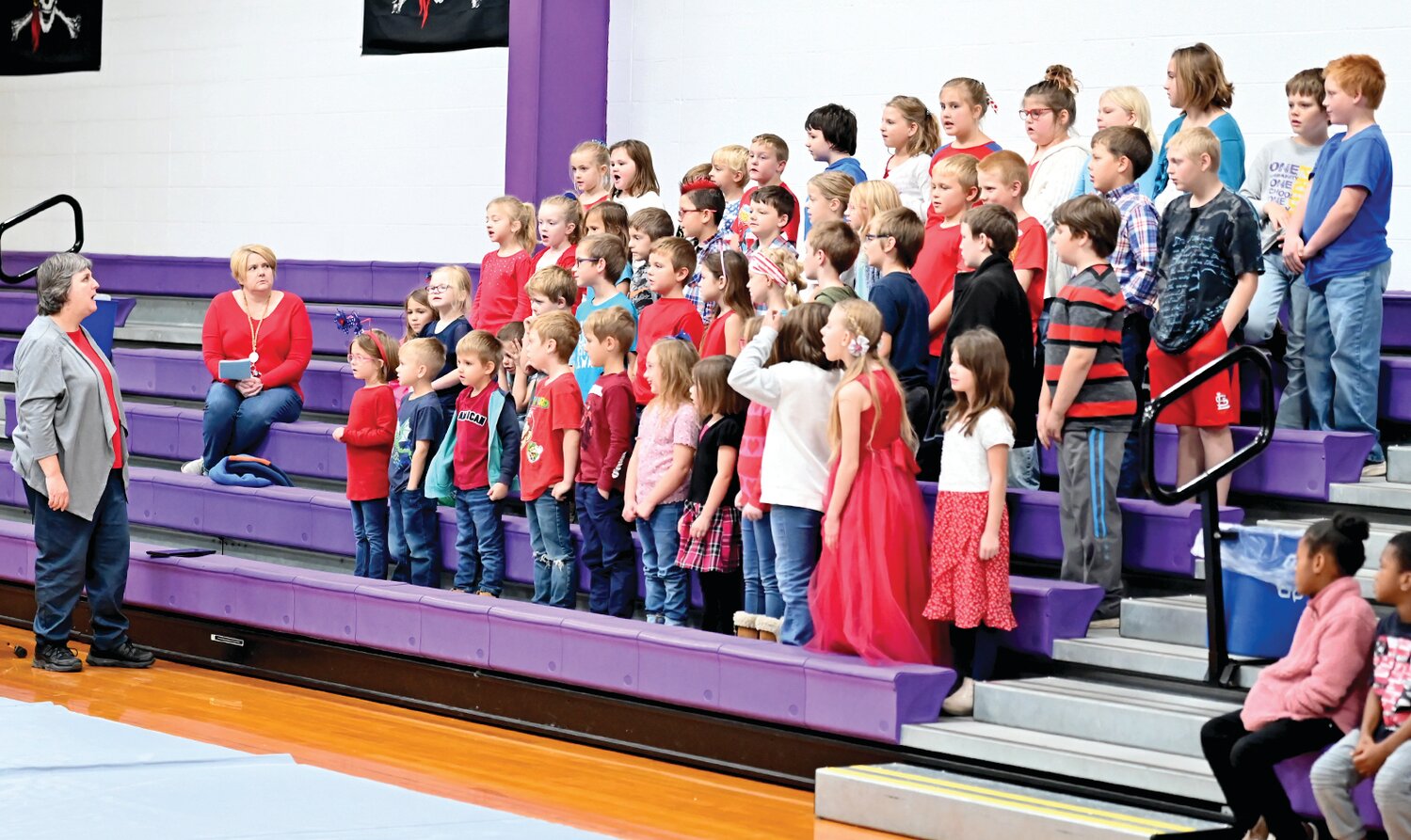 Chamois Band Teacher Beth Sieg leads elementary students in a song at Friday’s Veterans Day Assembly.