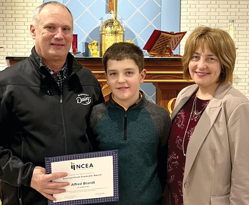 Alfred Brandt of Linn, a 1981 graduate of St. George, is shown with his wife, Sonya, and son, Sam, after receiving his National Catholic Education Association (NCEA) Distinguished Graduate Award.